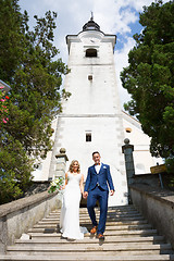 Image showing The Kiss. Bride and groom kisses tenderly on a staircase in front of a small local church.