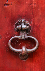 Image showing Vintage bright red wooden door with metallic knocker