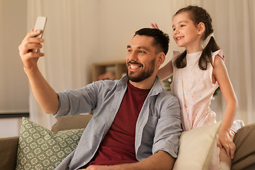 Image showing father and daughter taking selfie at home