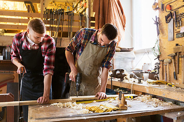 Image showing carpenters working with wooden board at workshop
