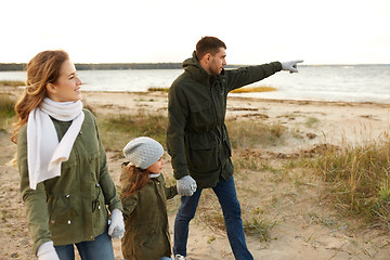 Image showing happy family walking along autumn beach