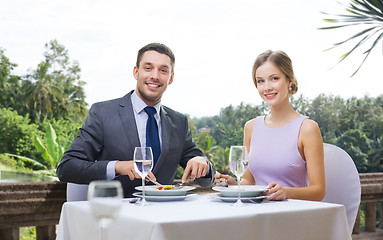 Image showing smiling couple eating appetizers at restaurant