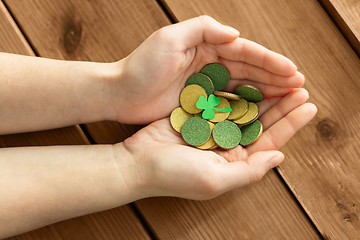 Image showing hands with golden coins and shamrock leaf