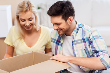 Image showing happy couple looking inside box or parcel at home