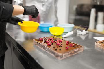 Image showing confectioner makes chocolate dessert at sweet-shop