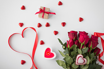 Image showing close up of red roses, gift, candies and candle