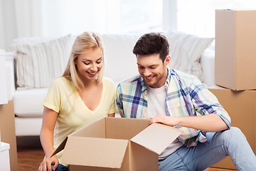 Image showing happy couple unpacking boxes at new home