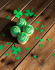 Image showing green cupcakes and shamrock on wooden table