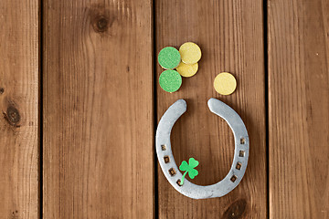 Image showing horseshoe with shamrock on wooden background