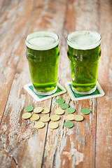 Image showing glasses of green beer and gold coins on table