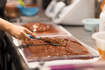 Image showing confectioner makes chocolate dessert at sweet-shop