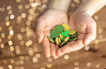 Image showing hands with golden coins and shamrock leaf