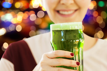 Image showing close up of woman with green beer in glass