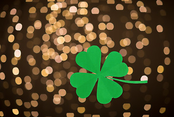 Image showing green paper shamrock over festive lights