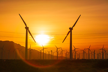 Image showing Silhouetted Wind Turbines Over Dramatic Sunset Sky