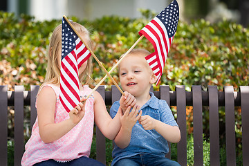 Image showing Young Sister and Brother Waving American Flags On The Bench At T