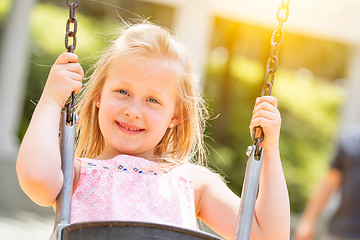 Image showing Pretty Young Girl Having Fun On The Swings At The Playground