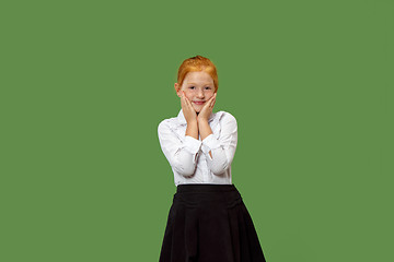 Image showing The happy teen girl standing and smiling against green background.