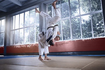 Image showing Two judo fighters showing technical skill while practicing martial arts in a fight club