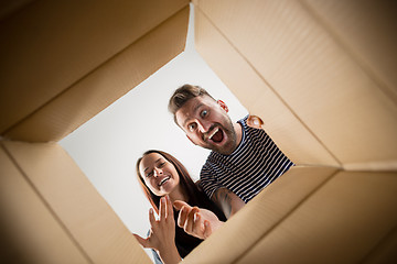 Image showing The couple unpacking and opening carton box and looking inside