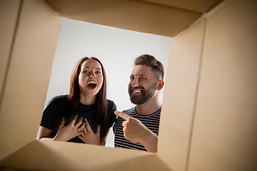 Image showing The couple unpacking and opening carton box and looking inside