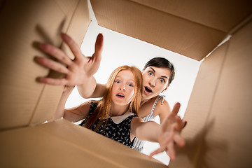 Image showing mom and daughter unpacking and opening carton box and looking inside