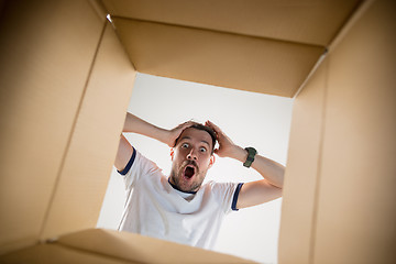 Image showing Man unpacking and opening carton box and looking inside