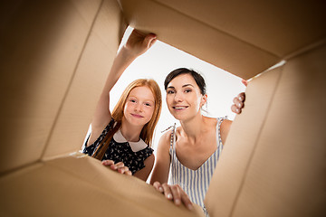 Image showing mom and daughter unpacking and opening carton box and looking inside