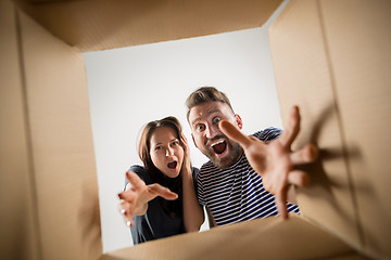 Image showing The couple unpacking and opening carton box and looking inside