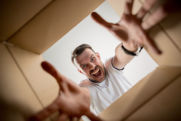 Image showing Man unpacking and opening carton box and looking inside