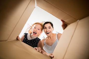 Image showing mom and daughter unpacking and opening carton box and looking inside