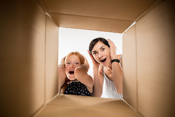 Image showing mom and daughter unpacking and opening carton box and looking inside