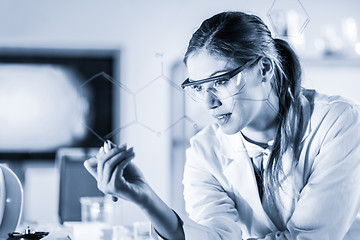 Image showing Portrait of a confident female researcher in life science laboratory writing structural chemical formula on a glass board.