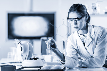 Image showing Portrait of a confident female researcher in life science laboratory writing structural chemical formula on a glass board.