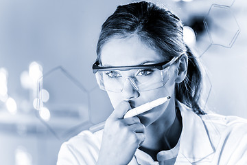 Image showing Portrait of a confident female researcher in life science laboratory writing structural chemical formula on a glass board.