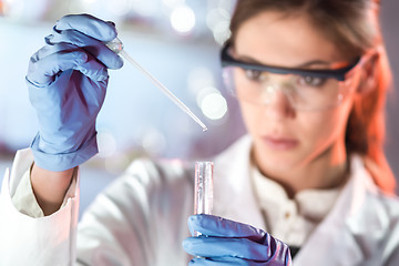 Image showing Young scientist pipetting in life science laboratory.