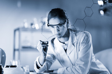 Image showing Portrait of a confident female researcher in life science laboratory writing structural chemical formula on a glass board.