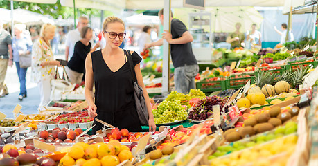 Image showing Woman buying fruits and vegetables at local food market. Market stall with variety of organic vegetable