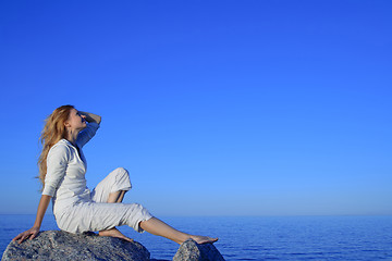 Image showing Relaxed young woman enjoying sunset by the sea