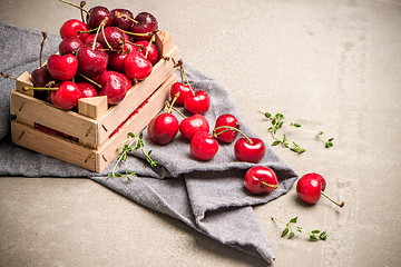 Image showing Red ripe cherries in small wooden box