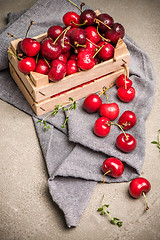 Image showing Red ripe cherries in small wooden box