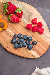 Image showing Wooden board with fresh organic fruit and berries