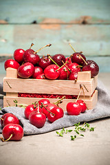 Image showing Red ripe cherries in small wooden box