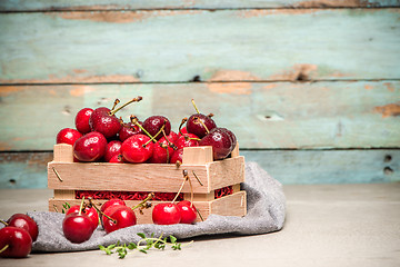 Image showing Red ripe cherries in small wooden box