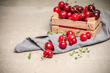 Image showing Red ripe cherries in small wooden box