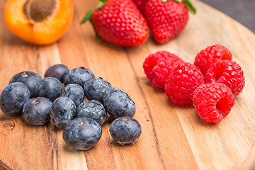 Image showing Wooden board with fresh organic fruit and berries