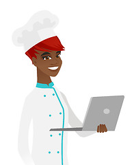 Image showing Young african-american chef using a laptop.