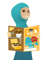 Image showing Young muslim business woman reading magazine.