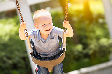 Image showing Happy Young Boy Having Fun On The Swings At The Playground