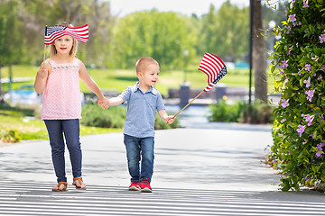 Image showing Young Sister and Brother Waving American Flags At The Park